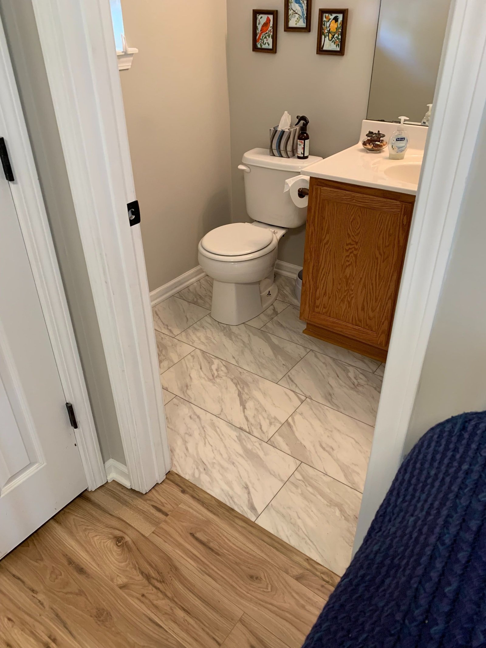 Half-bath after — new marble-look tile floor
